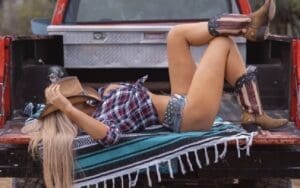 Lacey Evans Lounges On A Tailgate In Revealing Top & Daisy Dukes